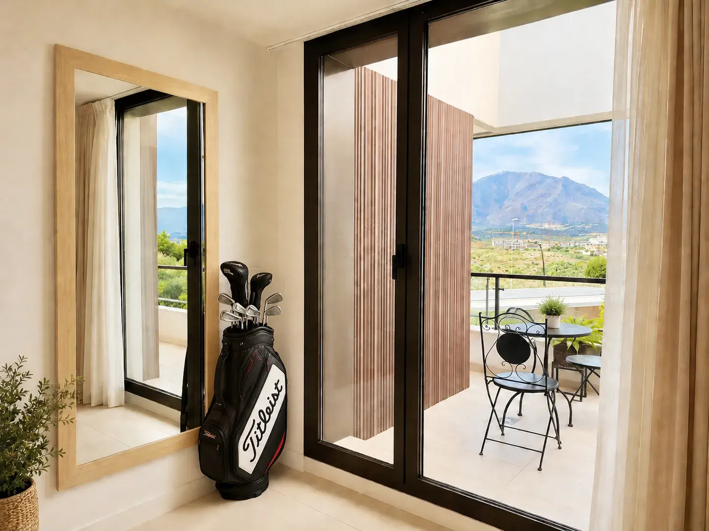 Bedroom with full-length mirror and terrace doors framing the Sierra Bermeja
