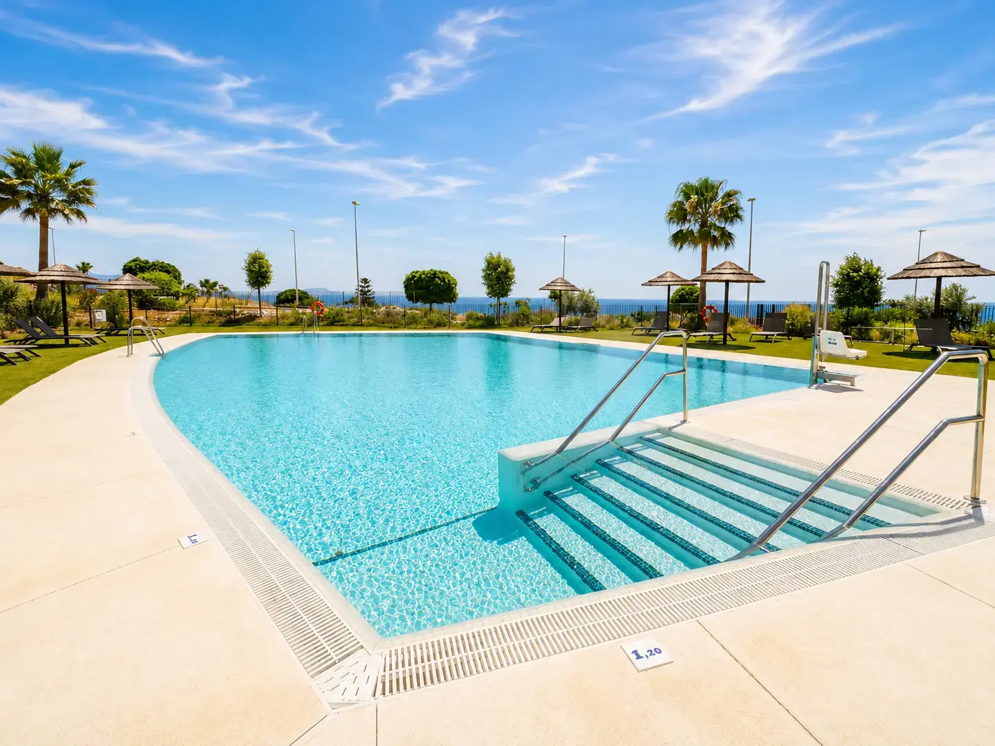 Community pool with sea views and wide entry steps in the landscaped gardens — Casares Costa