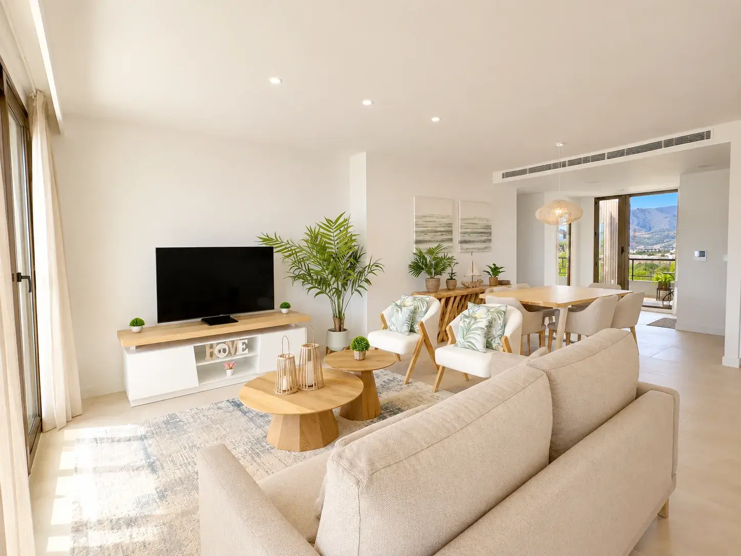 Bright living room with sofa and smart TV opening onto the terrace